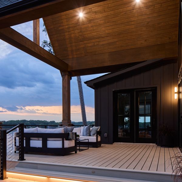 A view of the Trex deck in Salt Flat with high ceilings and attractive deck furniture decorating the space.